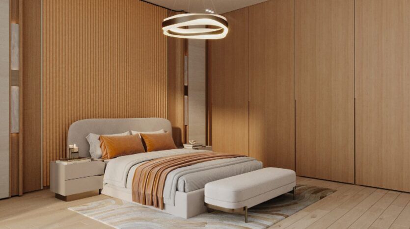 Chambre à coucher moderne avec un lit double, une literie Skyflame orange et beige, une banquette coussinée au pied, de grandes armoires en bois, un plafonnier circulaire et des touches de bois chaud sur les murs et le sol.
