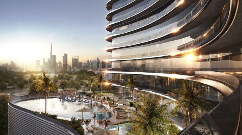 Immeuble moderne d'appartements de luxe avec balcons incurvés donnant sur une piscine sur le toit, des chaises longues et des palmiers, le tout sur fond de ciel enflammé et de coucher de soleil. L'emblématique Burj Khalifa se dresse à l'arrière-plan.
