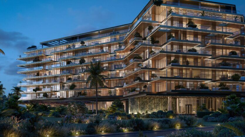 Un immeuble d'appartements de luxe moderne de plusieurs étages, les Résidences Cheval, est illuminé au crépuscule, avec de grandes baies vitrées, des balcons spacieux et des jardins paysagers luxuriants au premier plan. Des palmiers et des éclairages décoratifs renforcent l'ambiance élégante.