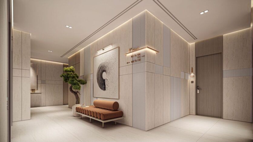 Un couloir moderne et minimaliste de Derby Heights présente des panneaux de bois clair, un éclairage encastré, un banc marron rembourré, un petit arbre en pot et une grande œuvre d'art abstraite près d'une porte grise portant l'inscription "105".