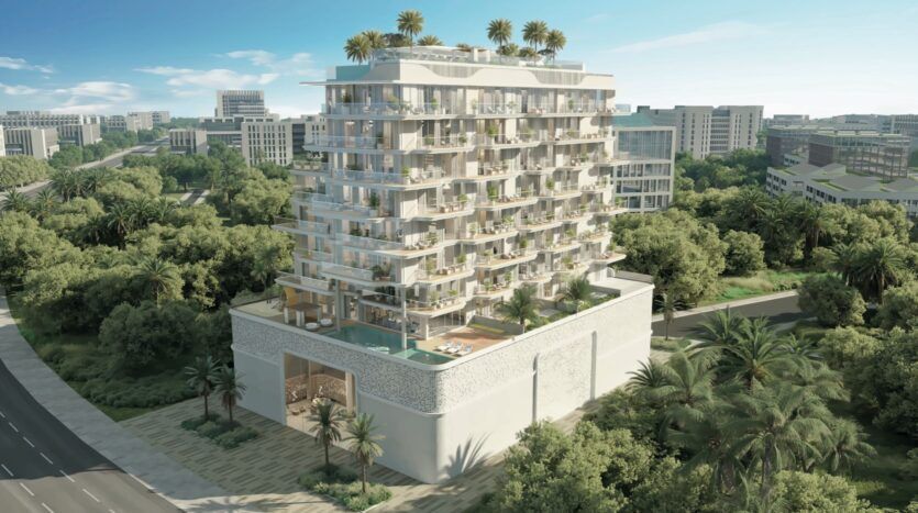 Un immeuble moderne de plusieurs étages avec des balcons et des jardins sur les toits, entouré d'arbres luxuriants et de verdure, se dresse dans la ville de Meriden, avec d'autres bâtiments visibles à l'arrière-plan.