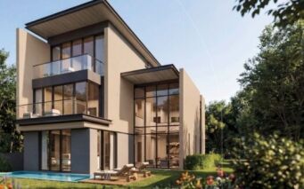 Maison moderne de trois étages à The Orchard by Sobha, avec de grandes baies vitrées et des balcons, entourée d'une végétation luxuriante et d'une pelouse bien entretenue, avec une petite piscine et des chaises longues dans l'arrière-cour par temps ensoleillé.