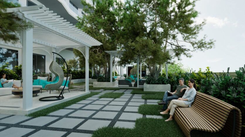 Un espace extérieur aménagé avec un banc moderne Reef 996, une pergola, des fauteuils suspendus et des arbres. Deux personnes s'assoient sur le banc, tandis que d'autres se détendent sous la pergola. L'espace est agrémenté de chemins pavés et d'une végétation luxuriante.