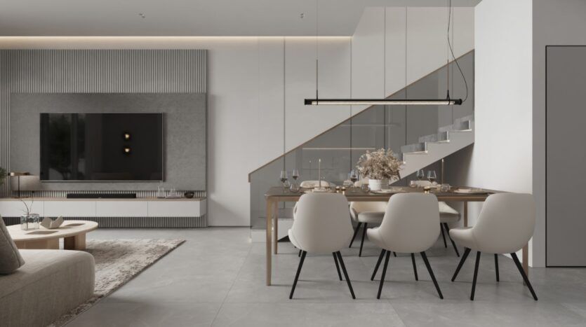 Un salon et une salle à manger modernes et minimalistes avec des tons neutres, un mobilier épuré et une élégance inspirée des jardins de Sakura. Vous y trouverez une grande télévision murale, une table à manger pour six personnes et un escalier avec une rampe en verre en arrière-plan.