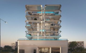 « Vue Dorée », un immeuble moderne de plusieurs étages, se distingue par ses balcons incurvés et ses piscines à chaque étage, se découpant sur un ciel clair du soir et entouré d’arbres et d’autres bâtiments.