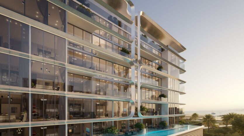 Le Vue Dorée se caractérise par un bâtiment moderne en verre de plusieurs étages, aux lignes architecturales courbes, doté de balcons et agrémenté de verdure. Une piscine à débordement longe le niveau inférieur, agrémentée de palmiers et offrant une vue lointaine sur l'océan en arrière-plan.