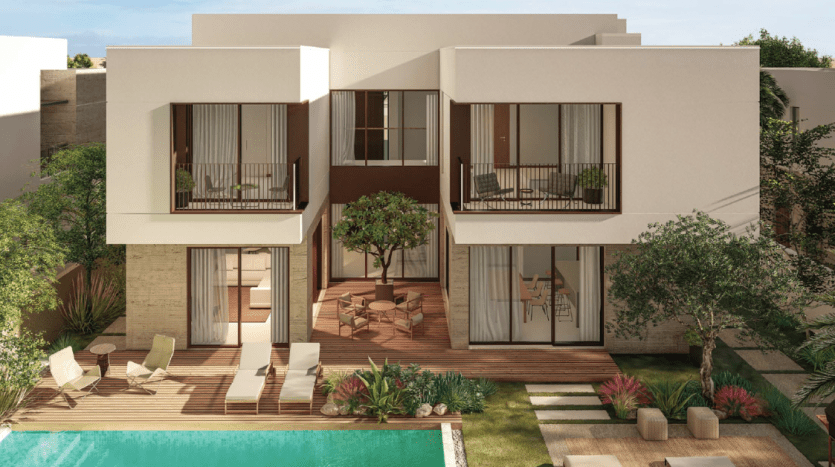 Modern villa in Dubai with white walls, large glass windows and balconies overlooking a swimming pool surrounded by wooden terraces and shaded by trees.