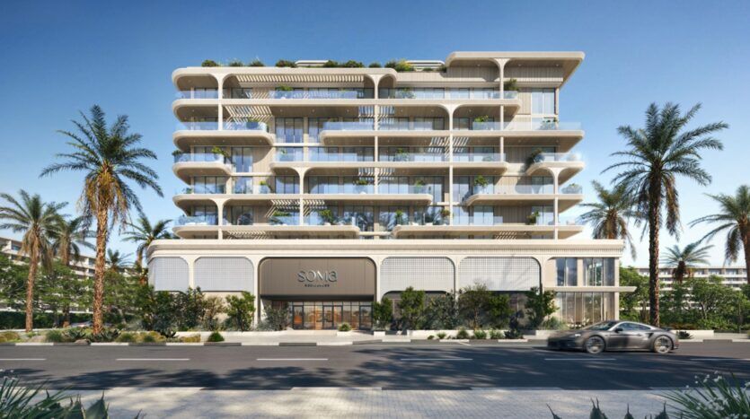 Immeuble moderne de plusieurs étages, doté de grandes baies vitrées, de balcons blancs et d'espaces verts à chaque étage, entouré de palmiers. Une voiture élégante passe devant l'entrée portant l'inscription « SONIA », qui fait partie de la collection haut de gamme Soma Residences.