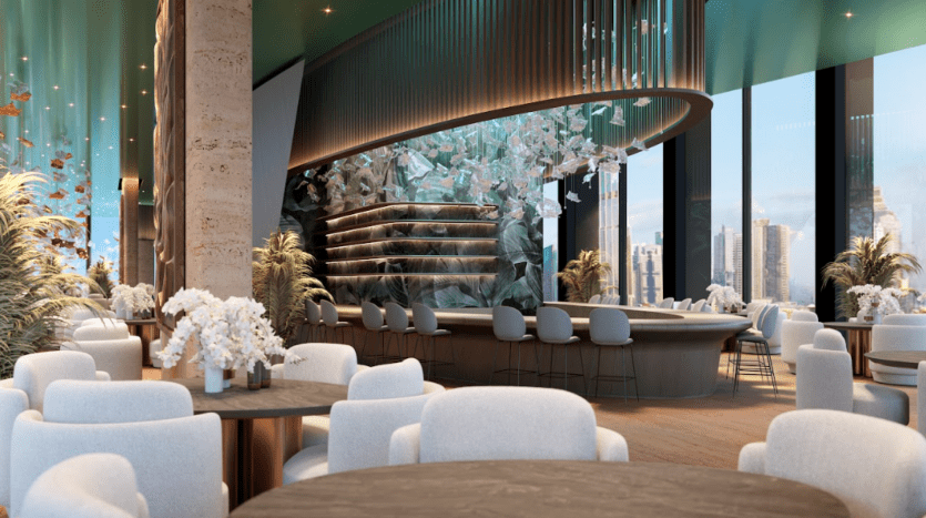 Un restaurant moderne et haut de gamme doté de baies vitrées offrant une vue sur le paysage urbain. Le mobilier contemporain comprend des chaises rembourrées blanches, des tables en bois sombre ornées d'arrangements floraux blancs, un bar incurvé avec des tabourets et une installation décorative au plafond.