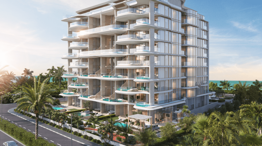 Vitalia est un immeuble résidentiel moderne de plusieurs étages doté de balcons en verre et de piscines extérieures à chaque niveau. Il est entouré de plantes et d'arbres tropicaux. Surplombant la zone côtière de Palm Jumeirah, la structure offre une vue imprenable sur la mer sous un ciel bleu clair.