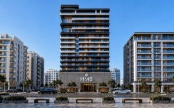 Le Beverly Crown, un gratte-ciel moderne signé HMB, se dresse fièrement, avec son enseigne emblématique, au milieu d'immeubles d'habitation de hauteur moyenne, d'arbres et d'une circulation animée. Des bancs et le trottoir agrémentent le premier plan sous un ciel bleu limpide.