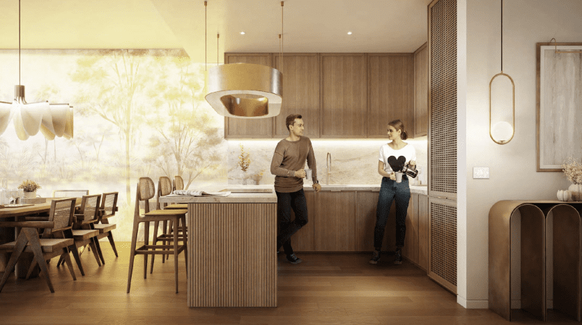 A modern kitchen and dining area in a Dubai apartment with a couple, a man and a woman, casually conversing. The room is warmly lit with natural wood finishes and gold fixtures.