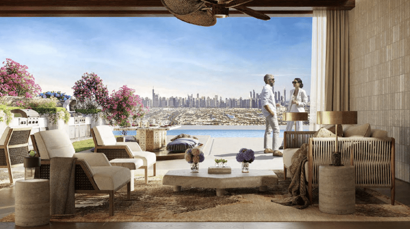 A luxurious open terrace overlooking the rooftops of Dubai city, with a couple standing and chatting. Décor includes modern furnishings, flowers and unobstructed views of the waterfront and skyscrapers.