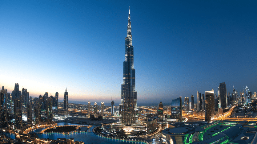 Vista panoramica di Dubai al tramonto, con il Burj Khalifa illuminato che sovrasta i grattacieli circostanti e le strade illuminate della città, evidenziando le migliori opzioni immobiliari di Dubai.