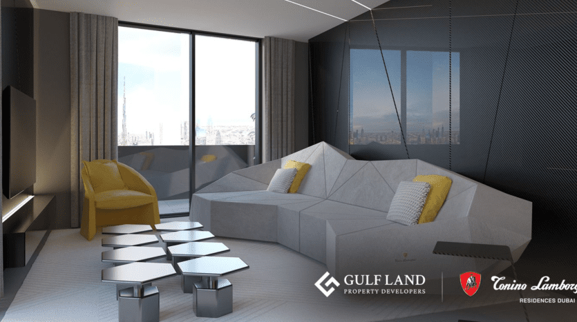 A modern living room with a gray geometric sofa, a yellow chair and metallic hexagonal side tables. Large windows offer city views. The Gulf Land Property Developers and Tonino Lamborghini Residences Dubai logos can be seen in the lower right-hand corner.