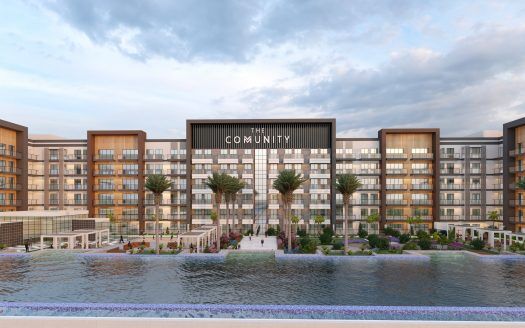 Representación digital de un moderno complejo residencial llamado "The Community", formado por edificios de varias plantas con balcones, rodeado de palmeras y bordeado por una pintoresca extensión de agua, ideal para quienes buscan