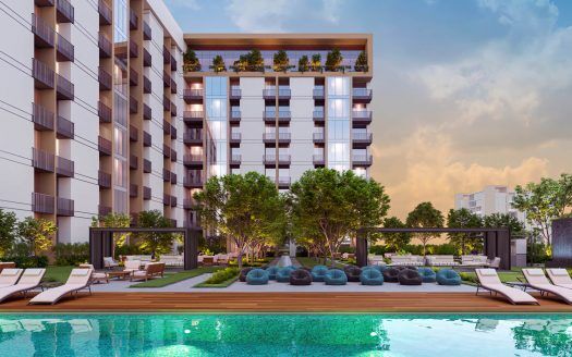 Moderno edificio de apartamentos en Dubai con balcones que dan a la piscina y cuentan con tumbonas, quioscos y asientos de lujo en medio de un exuberante paisaje al atardecer.