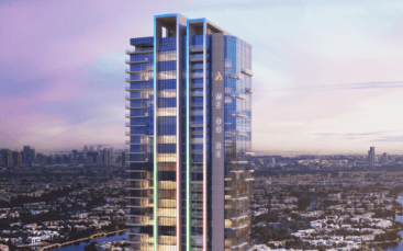 Un immeuble de grande hauteur aux sols éclairés et à la signalétique « ami dior », surplombant un paysage urbain baigné par la lueur chaleureuse d'un coucher de soleil à Dubaï.