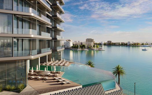 Lujoso rascacielos en el paseo marítimo de Dubai con balcones que dan a un puerto deportivo lleno de barcos, piscina infinita y tumbonas.