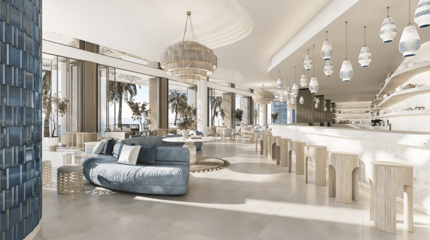 Un hall luxueux et spacieux au décor moderne comprenant un canapé bleu, des tabourets en bois, des tables rondes, des lampes suspendues et de grandes fenêtres avec vue sur les palmiers dans une villa exclusive à Dubaï.