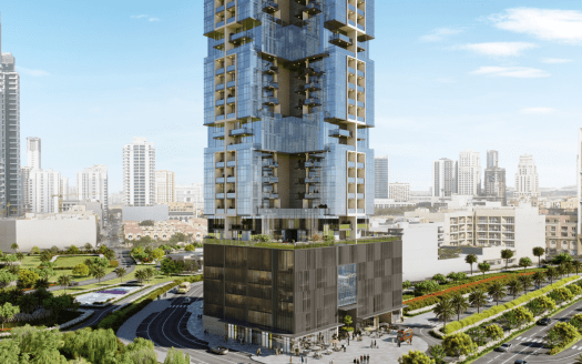 Un moderno rascacielos con amplias fachadas de cristal y verdes balcones destaca en un entorno urbano, rodeado de frondosos parques y otros rascacielos bajo un cielo despejado en Dubai.