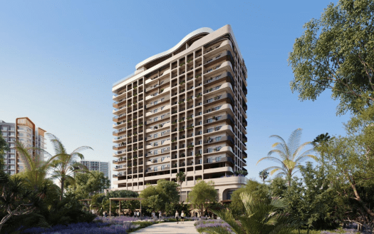Un moderno edificio residencial de gran altura rodeado de exuberantes jardines, con gente paseando por senderos y palmeras meciéndose en primer plano bajo un cielo azul despejado, disponible a través de una importante agencia inmobiliaria de Dubai.