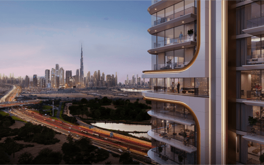 Belgrove Residences, un moderno edificio de apartamentos de gran altura con balcones iluminados, tiene vista a una transitada autopista y a un espacio verde al atardecer. El paisaje urbano al fondo presenta numerosos rascacielos, incluida una torre alta icónica. El cielo es un suave degradado del azul al rosa.