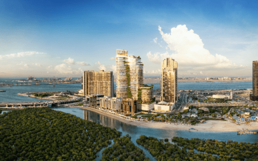 Vista aérea de Rivage, un paisaje urbano costero con modernos rascacielos a orillas de una vía fluvial y exuberantes manglares verdes. El horizonte bajo un cielo azul despejado pone de relieve la armoniosa mezcla de desarrollo urbano y paisaje natural.