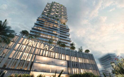 Un moderno y lujoso rascacielos de varias plantas se alza orgulloso en Cove Boulevard, envuelto en vegetación bajo un cielo nublado. Los grandes ventanales reflejan el entorno, mientras que "IWLAZ" marca su entrada. En primer plano, palmeras y flores de vivos colores crean un oasis acogedor.