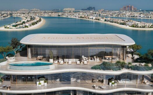 Un lujoso ático en la azotea de Maison Margiela Residences cuenta con una piscina y asientos al aire libre, con vistas al mar y a las islas de Palm Jumeirah en Dubai. Diseño moderno y vistas panorámicas al mar definen esta exclusiva escapada.