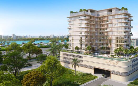 Sunset Bay Grand Residence by Imtiaz en Dubai Islands, un moderno edificio de varias plantas con grandes balcones, rodeado de palmeras y vegetación, ofrece vistas de la ciudad y del paseo marítimo bajo un cielo azul despejado.