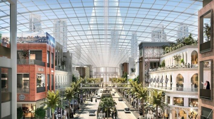 Intérieur d'un centre commercial moderne à Dubaï avec un plafond transparent, comprenant des magasins à plusieurs niveaux, des sentiers piétonniers et une verdure luxuriante, éclairés par la lumière naturelle.