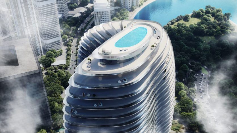 Un gratte-ciel futuriste au design incurvé unique, doté d'une piscine ovale sur le toit. La structure est entourée d'autres gratte-ciel et espaces verts, ce qui en fait un investissement idéal à Dubaï.