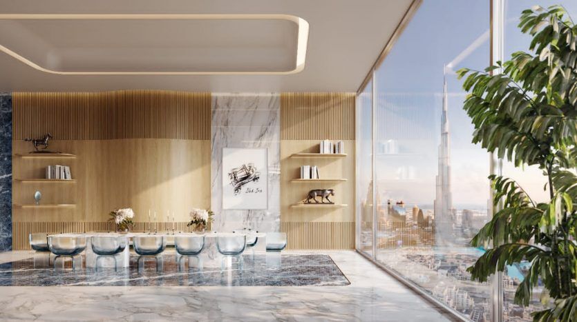 Cuisine de luxe moderne dans un appartement de Dubaï avec sol en marbre, murs en bois et marbre bleu, longue table à manger avec chaises en verre et baies vitrées affichant un paysage urbain.