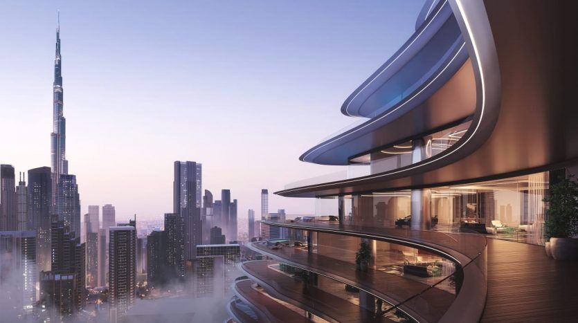 Le balcon incurvé d'un immeuble moderne de grande hauteur surplombe les toits de la ville au crépuscule à Dubaï, avec des gratte-ciel et la silhouette d'une haute tour en arrière-plan.