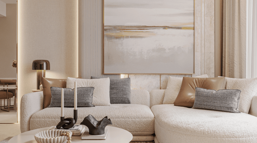 Un salon moderne avec un canapé blanc incurvé, des coussins gris et marron et une table basse ronde ornée de bougies et de décorations. Un grand tableau abstrait représentant un ciel de fleurs orne le mur, emplissant l'espace de tons neutres et chaleureux.