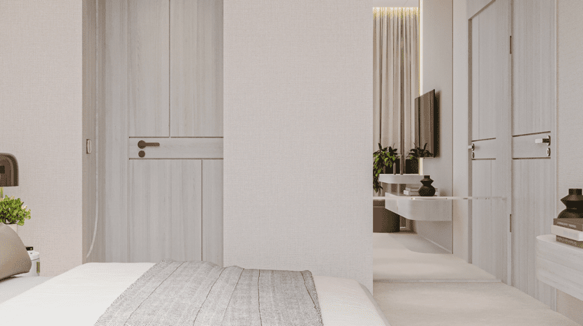 Chambre minimaliste avec des murs et des meubles de couleur claire, un lit avec une couverture grise, des œuvres d'art de ciels floraux au-dessus de la tête de lit, une porte en bois fermée, une télévision murale, des plantes d'intérieur et des objets décoratifs sur une étagère et une table.