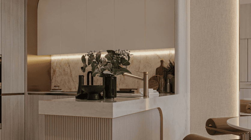 Cuisine moderne avec placards beige clair et crédence en marbre. Un élégant robinet noir et or trône sur un plan de travail clair. Plante verte en pot, vaisselle et planches à découper agrémentent la décoration. Sous la douce lumière tamisée des placards, une ambiance chaleureuse se crée.