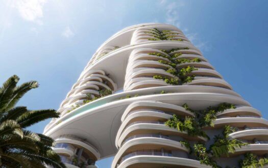 Amali Residences est un immeuble moderne de grande hauteur avec des balcons incurvés, chacun bordé de plantes vertes luxuriantes, se détachant sur un ciel bleu. Un palmier est visible au premier plan sur le côté gauche.
