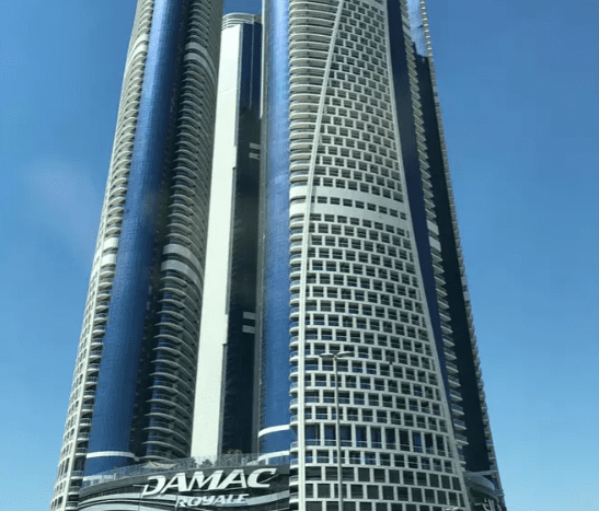 A view of Damac Towers Paramount, with elegantly designed modern skyscrapers under a clear blue sky.