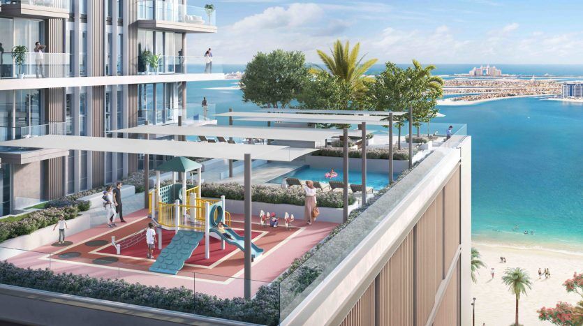 Luxueux complexe d'appartements en bord de mer sur Beach Isle avec des résidents bénéficiant de diverses commodités, notamment une aire de jeux, une salle de sport extérieure et des terrasses, donnant sur une plage ensoleillée et une mer d'un bleu cristallin.