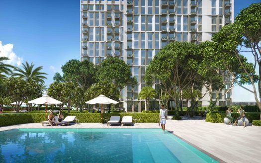 Una vista panoramica della piscina di un hotel di lusso con gli ospiti che si rilassano sui lettini, circondati da una vegetazione lussureggiante e dal moderno edificio Collective 2.0 Dubai Hills sullo sfondo.