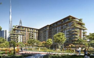 Complexe résidentiel verdoyant et luxuriant avec des bâtiments modernes à plusieurs étages, des jardins paysagers rappelant un parc central et des personnes pratiquant des activités de plein air par une journée ensoleillée, avec un grand gratte-ciel visible en arrière-plan.