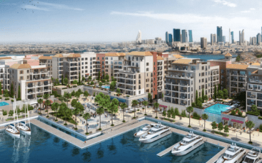 Une vue panoramique d'un luxueux quartier résidentiel en bord de mer à La Voile Port de la Mer, avec des bâtiments modernes, des piscines, une marina avec des yachts, une verdure luxuriante et un fond de