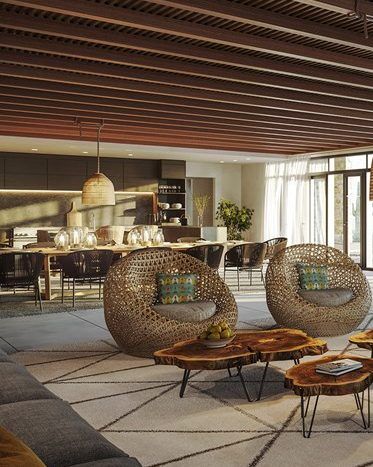 Salon moderne avec chaises circulaires al jure uniques, tables basses en bois, tapis géométrique et cuisine élégante visible en arrière-plan. Un éclairage chaleureux et des lattes de plafond en bois ajoutent une ambiance chaleureuse.