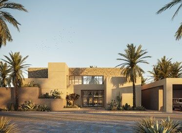 Une maison moderne de plain-pied avec de grandes fenêtres, entourée de palmiers et d'un paysage désertique sous un ciel dégagé au coucher du soleil à Al Jure.