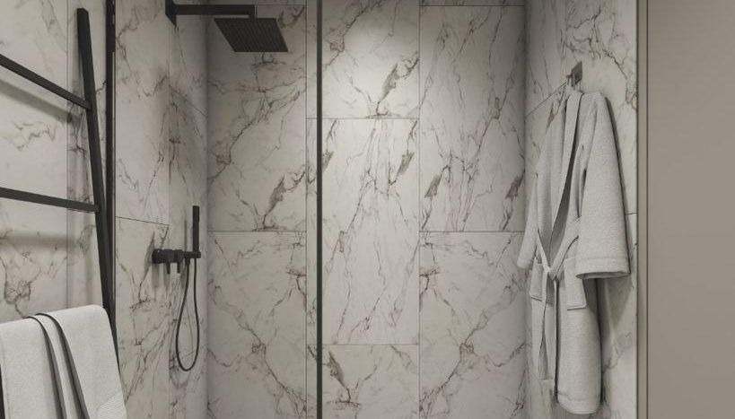 Une salle de bain moderne dotée d'une douche à l'italienne entourée de portes vitrées aux cadres noirs, sur fond de murs et de sols en marbre. Il y a des serviettes soigneusement suspendues sur un côté, brodées de l'élégant Reg