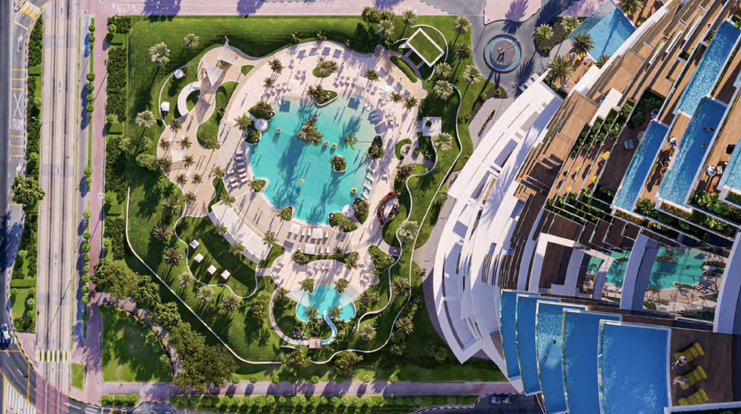 Aerial view of a hotel complex with round pools surrounded by sun loungers and palm trees, reminiscent of Dubai's luxurious Roberto Cavalli tower. The complex comprises a large building with balconies, located close to roads and lush green spaces.