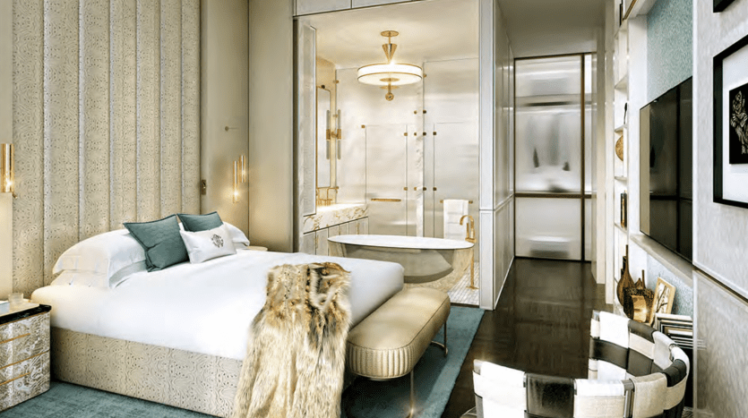 Luxurious room in a Dubai villa featuring a king-size bed with pastel bedding, elegant wall panels and a plush fur throw. The room features modern furniture, a round table and an elegant