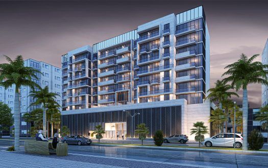 Un moderno edificio a più piani al tramonto, con interni ed esterni illuminati. Le palme costeggiano la strada di fronte a Prime Residency 3 e le persone sono in primo piano, evidenziando la vita cittadina.